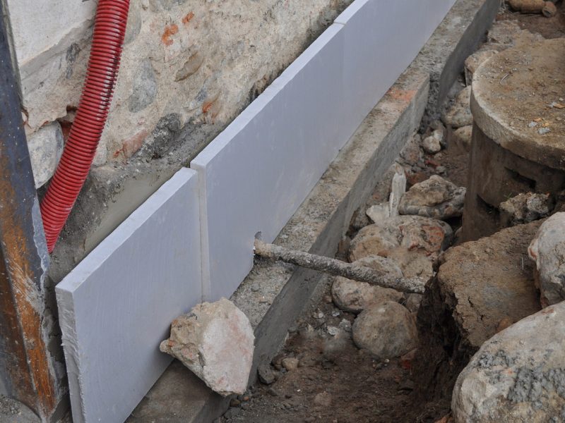 Foundation repair process with support panels showing the initial stage of underpinning a wall.