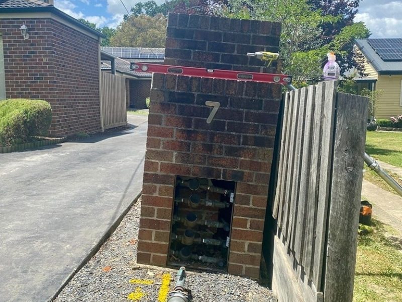 Leaning brick letterbox beside fence showing clear signs of subsidence in residential property.