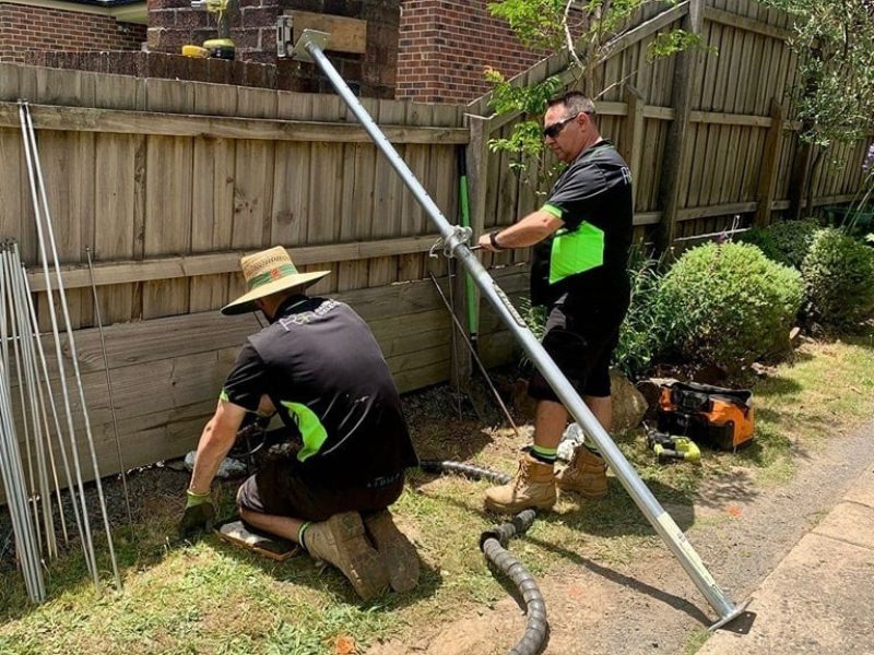 Contractors using equipment to repair house foundations after identifying signs of subsidence.
